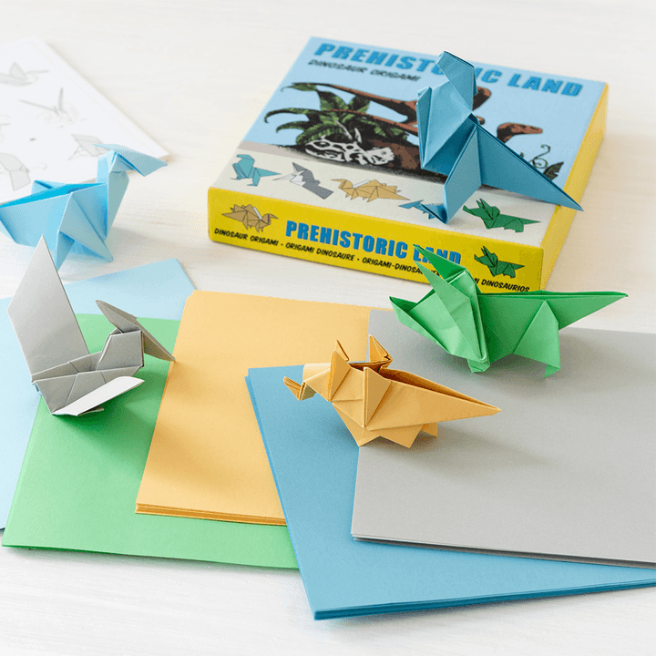 Prehistoric Land dinosaur origami box, coloured paper sheets and folded paper dinosaurs.