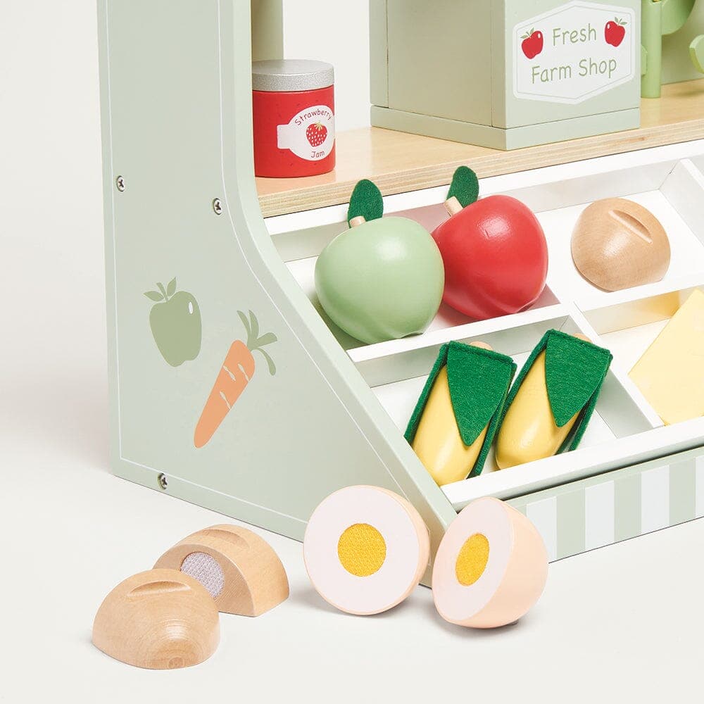 Wooden tabletop farm market stall with produce, flowers, scales and shopping bag